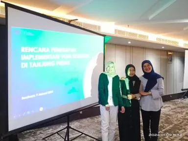 Alika with two speakers beside a projected presentation