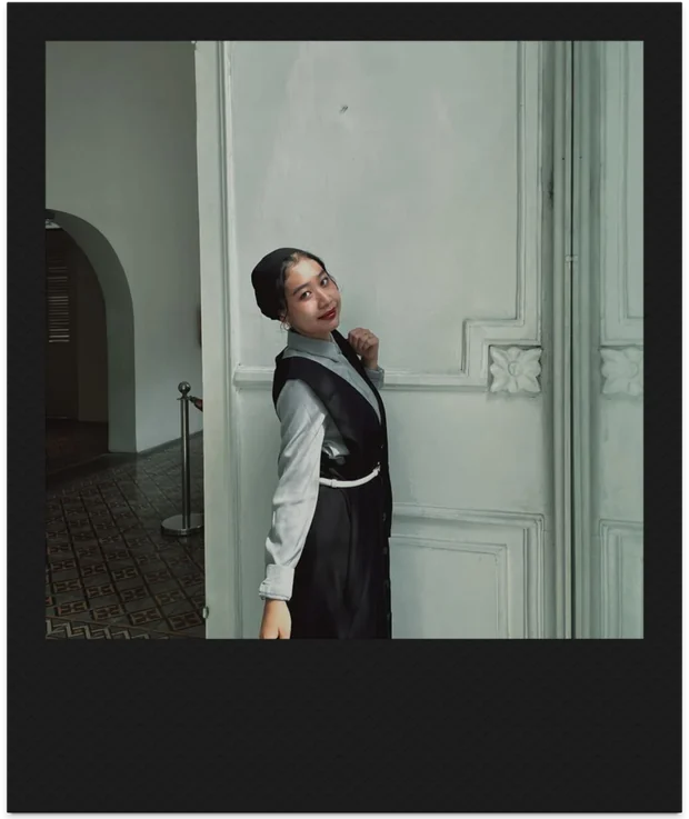 Alika leaning out from a tall pale-green door